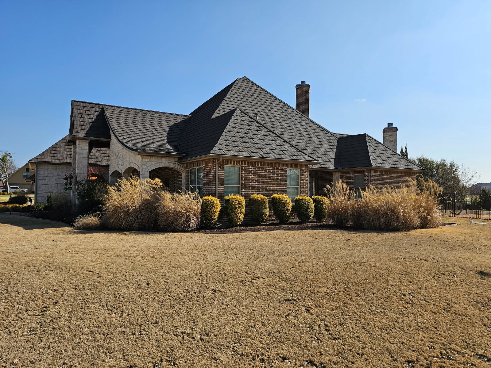 A large estate home with a charcoal WeatherLok stone-coated steel shake roof