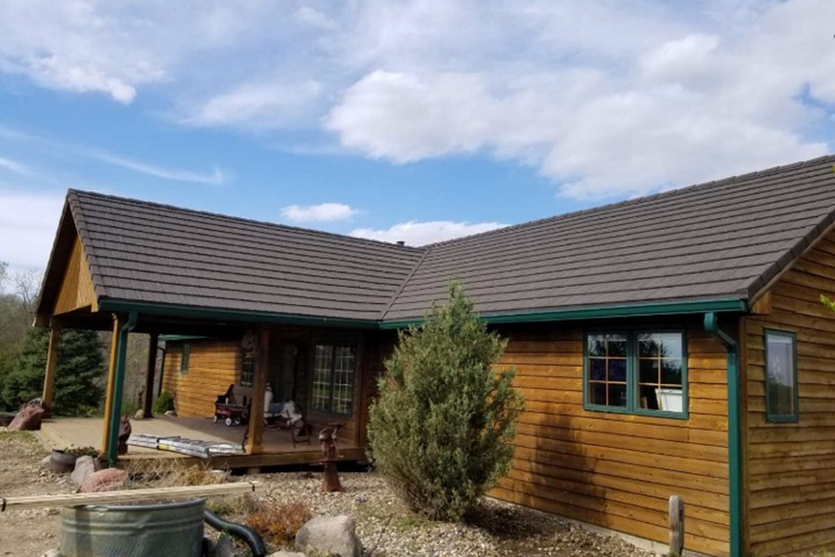 Weatherwood Shake on a cabin home, warm brown stone-coated steel